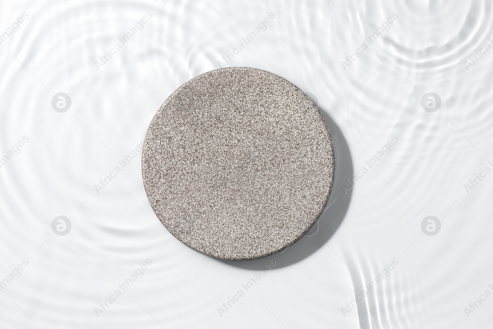 Photo of Presentation for product. Stone podium in water on white background, top view