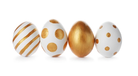 Photo of Line of traditional Easter eggs decorated with golden paint on white background