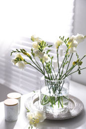 Beautiful spring freesia flowers on table in room