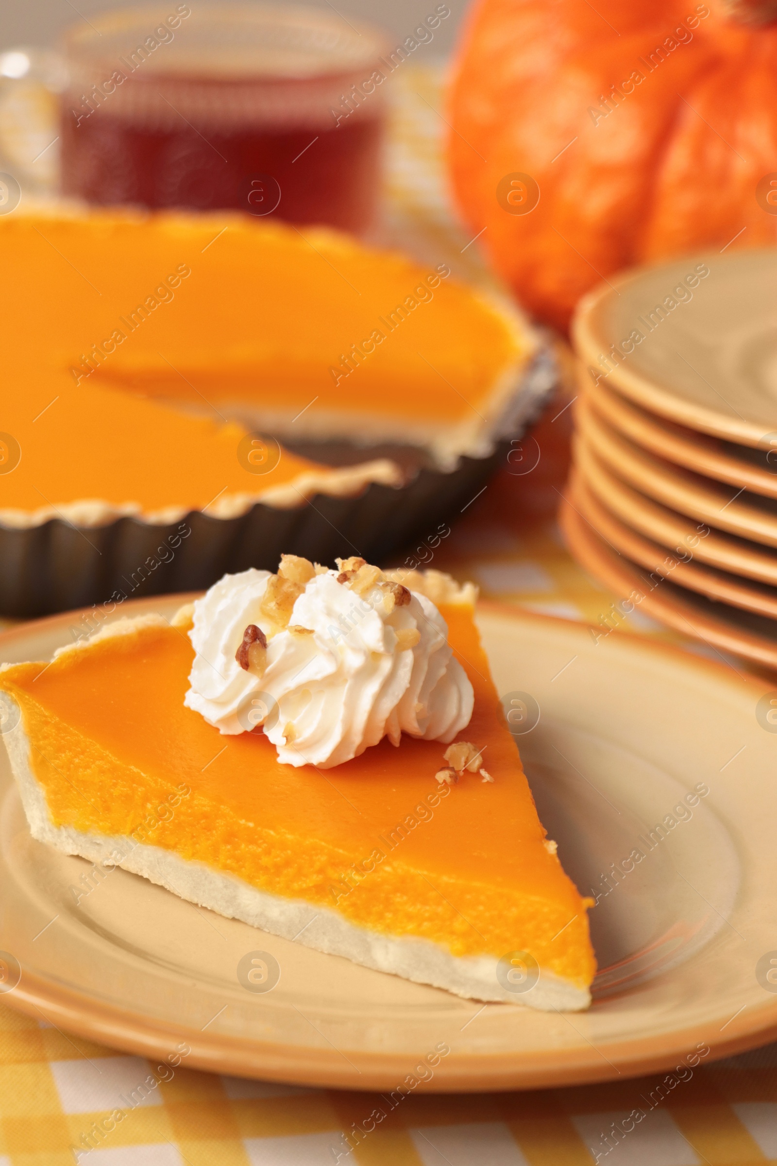 Photo of Piece of fresh homemade pumpkin pie with whipped cream on table