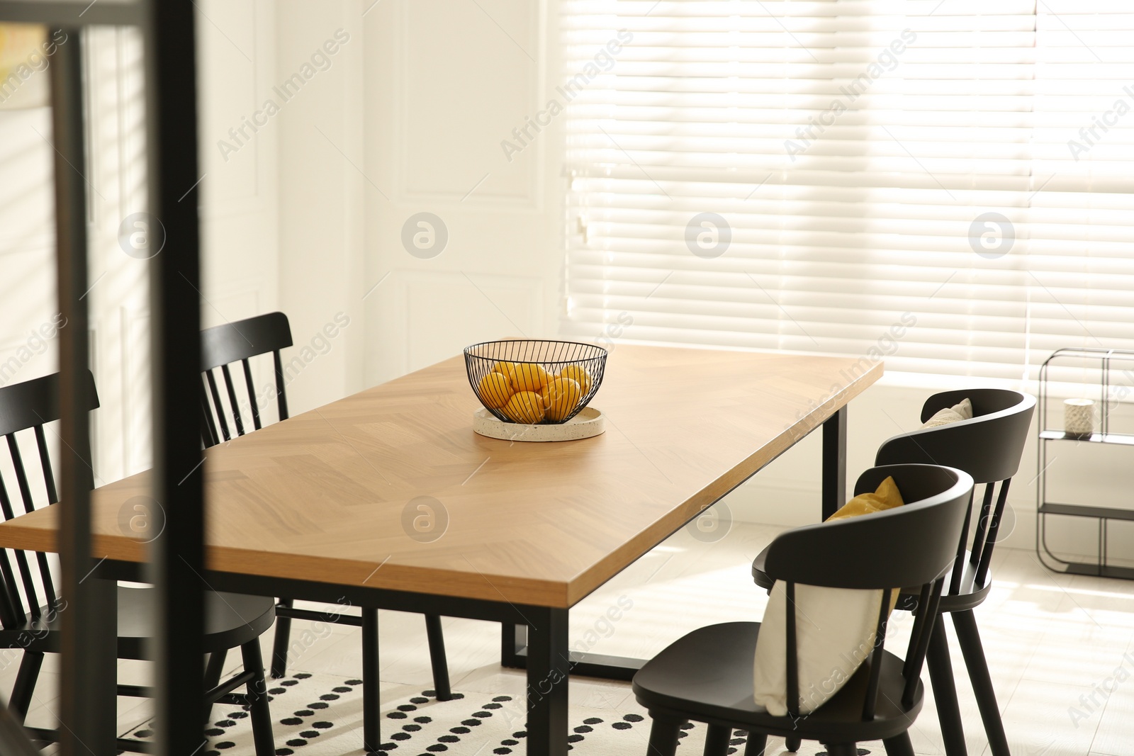 Photo of Stylish wooden dining table and chairs in room. Interior design