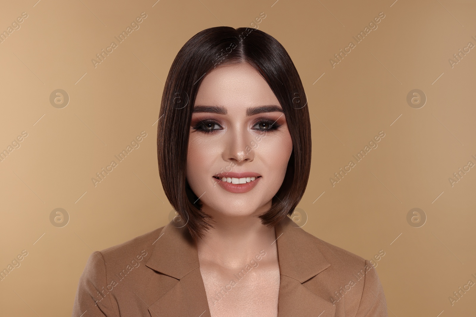 Image of Portrait of stylish young woman with brown hair smiling on beige background