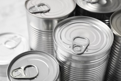 Many closed tin cans on table, closeup