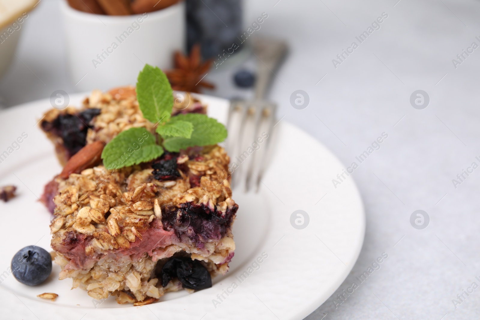 Photo of Tasty baked oatmeal with berries on light table, closeup