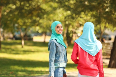 Muslim women walking in park on sunny day