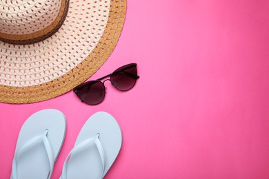 Photo of Straw hat, stylish sunglasses and flip flops on pink background, flat lay with space for text. Beach accessories