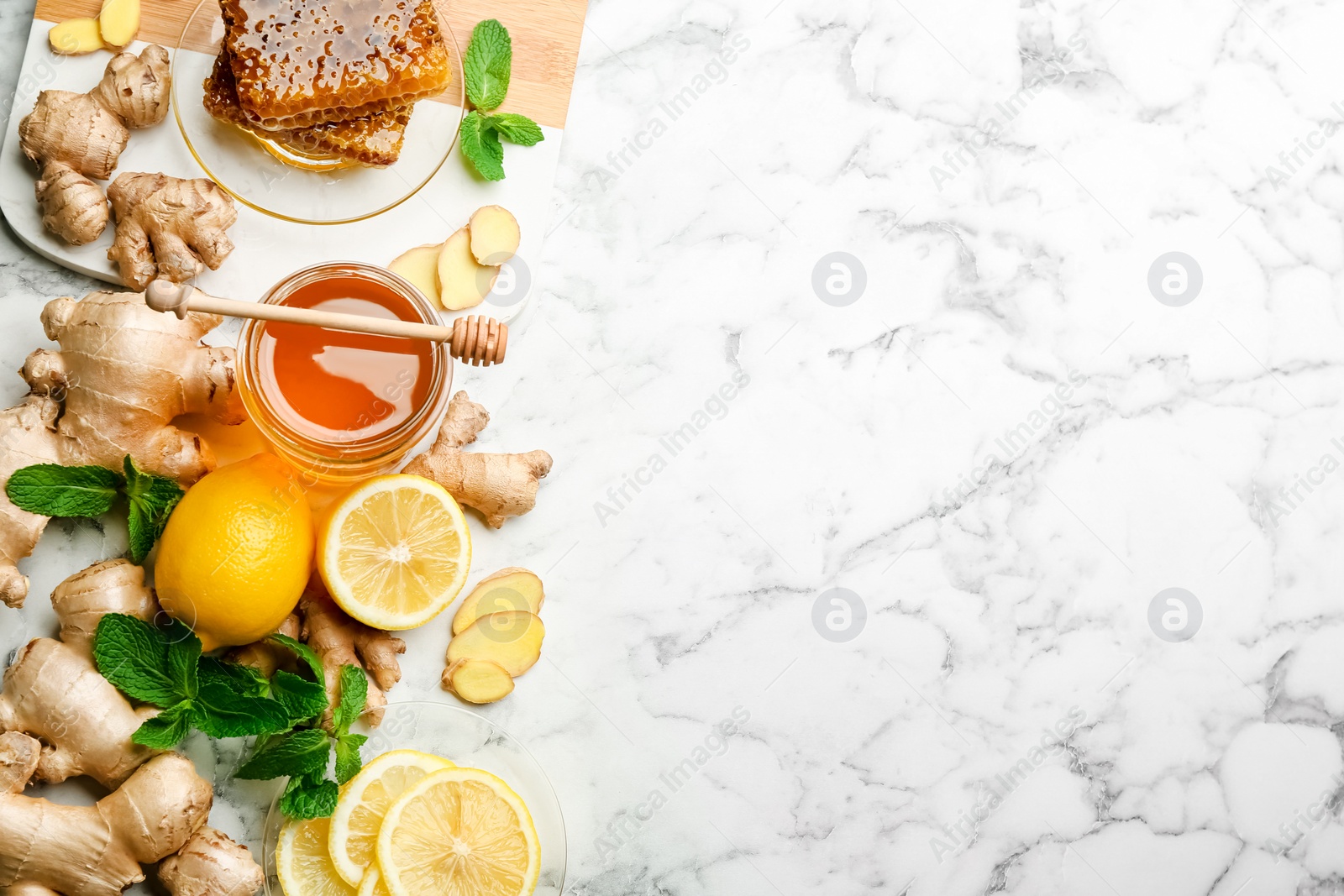 Photo of Ginger and other natural cold remedies on white marble table, flat lay. Space for text