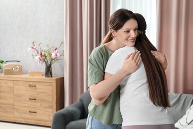 Photo of Doula hugging pregnant woman at home, space for text. Preparation for child birth