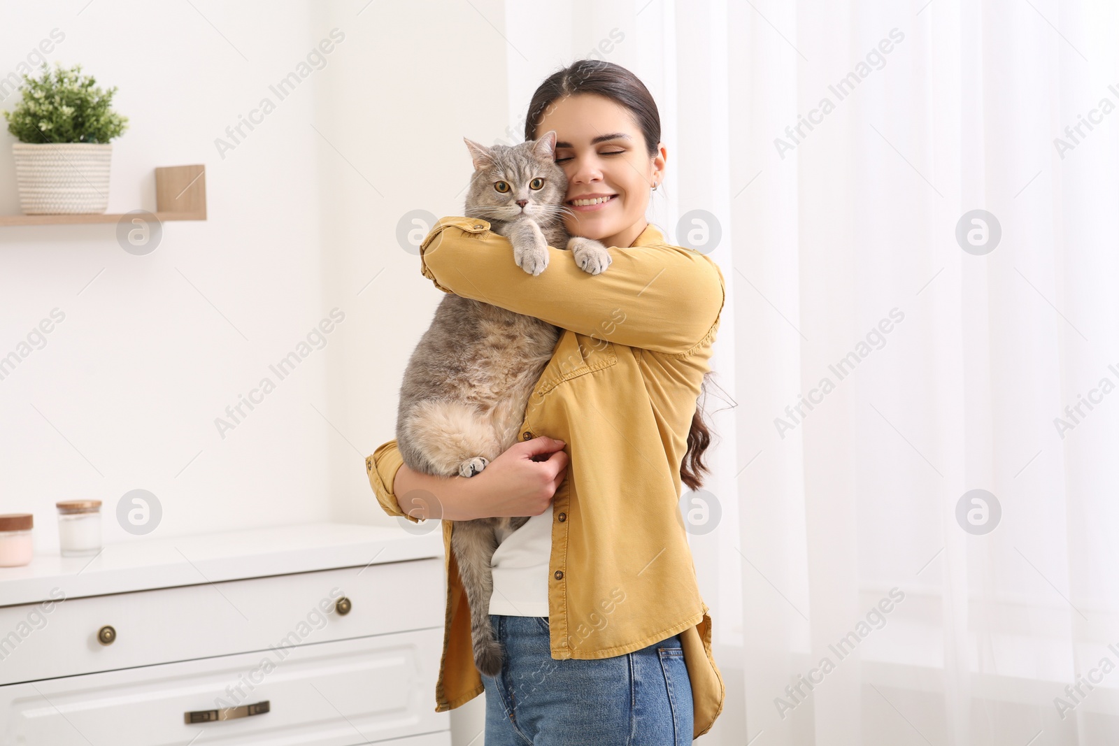 Photo of Young woman with adorable cat at home