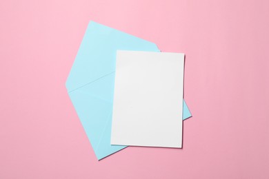 Photo of Letter envelope and card on pink background, top view