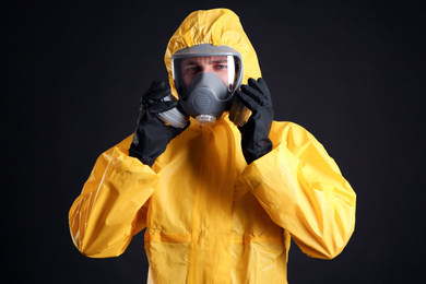 Photo of Man wearing chemical protective suit on black background. Virus research