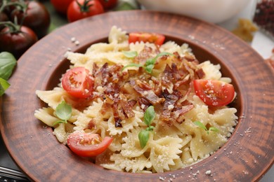 Photo of Tasty pasta with bacon, tomatoes and basil on table, closeup