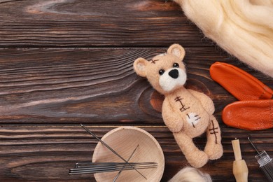 Photo of Felted bear, wool and tools on wooden table, flat lay. Space for text