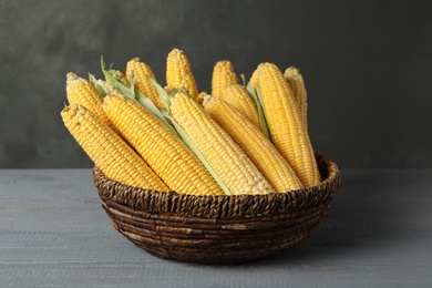 Photo of Corn cobs in bowl on grey wooden table