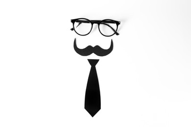 Photo of Fake mustache, tie and glasses on light background, top view
