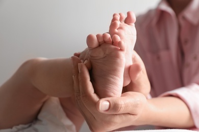 Photo of Mother holding her baby, closeup on feet