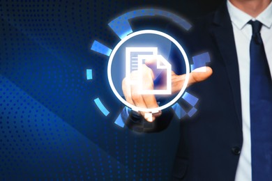 Image of Man pointing at virtual icon of computer file on dark blue background, closeup