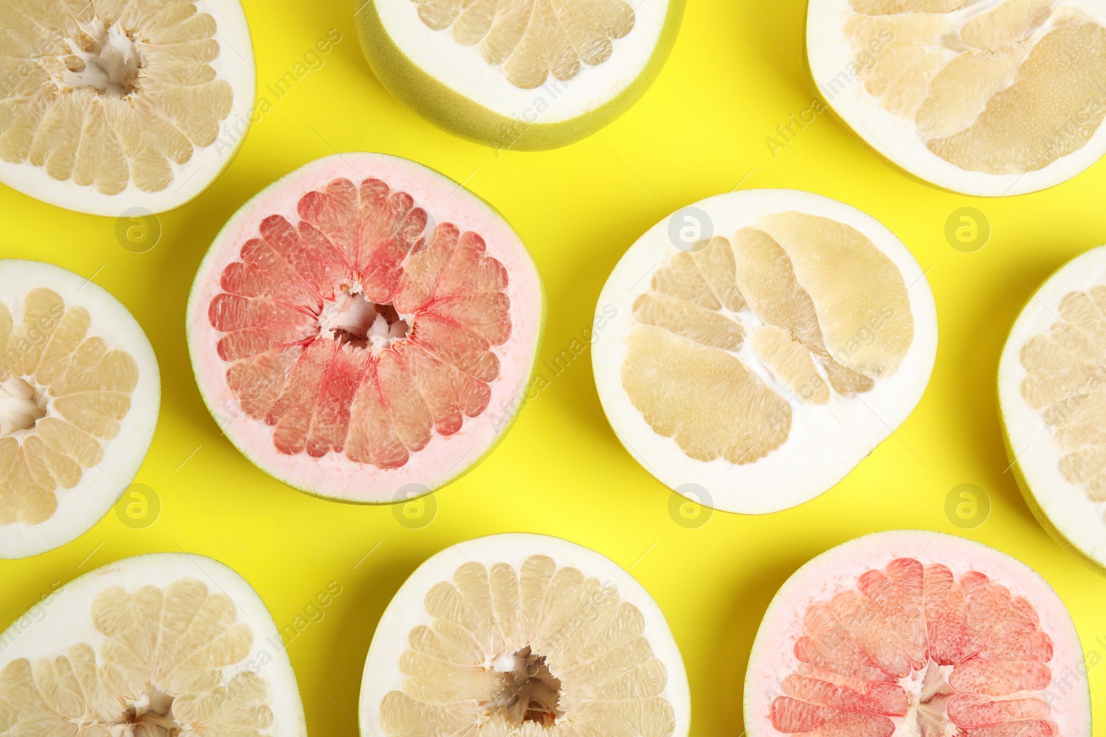 Photo of Fresh cut pomelo fruits on yellow background, flat lay