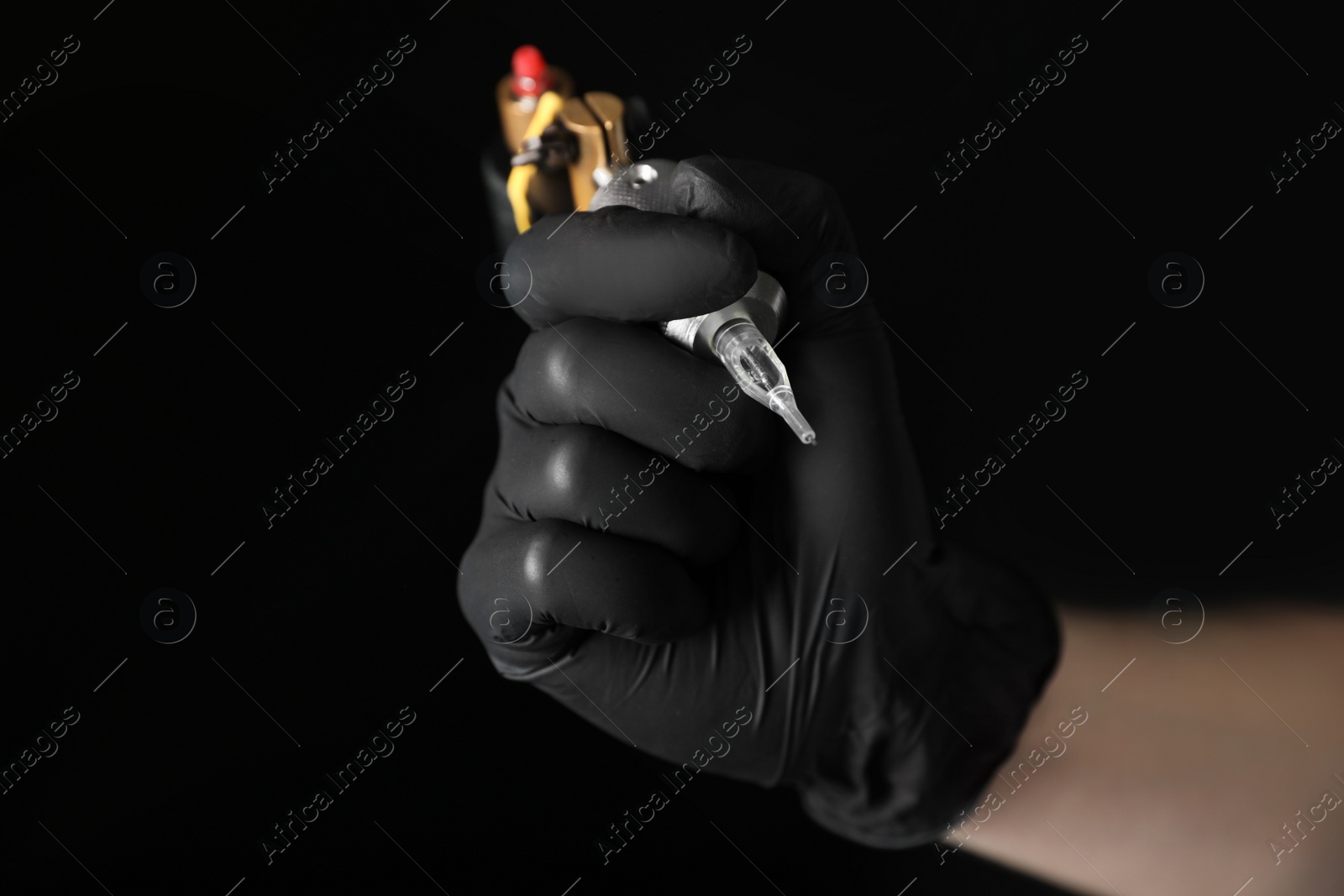 Photo of Tattoo artist with professional machine on black background, closeup