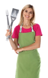 Woman in apron with barbecue utensils on white background