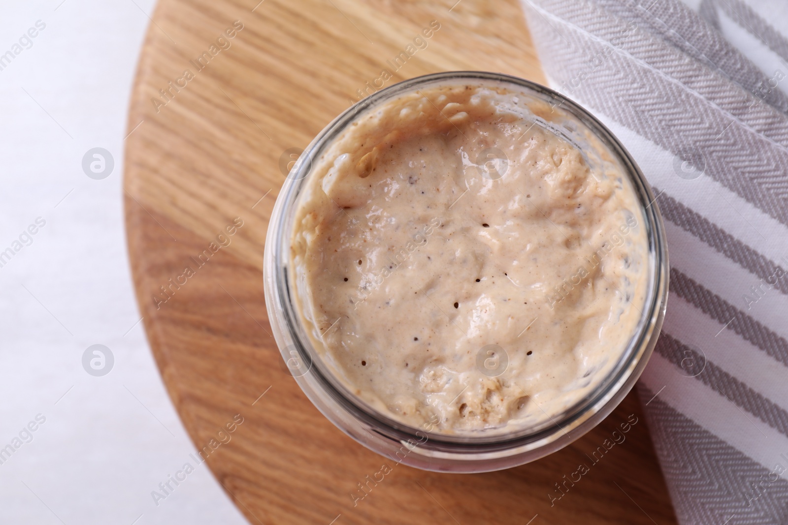 Photo of Sourdough starter in glass jar on light table, top view