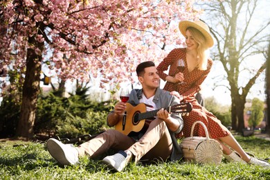 Photo of Lovely couple having picnic in park on sunny spring day