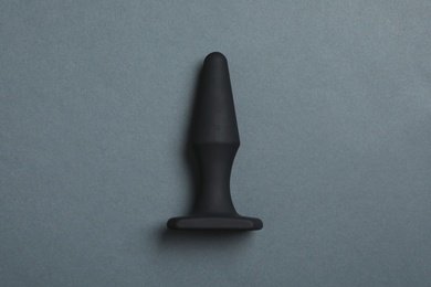 Photo of Black anal plug on dark background, top view. Sex toy