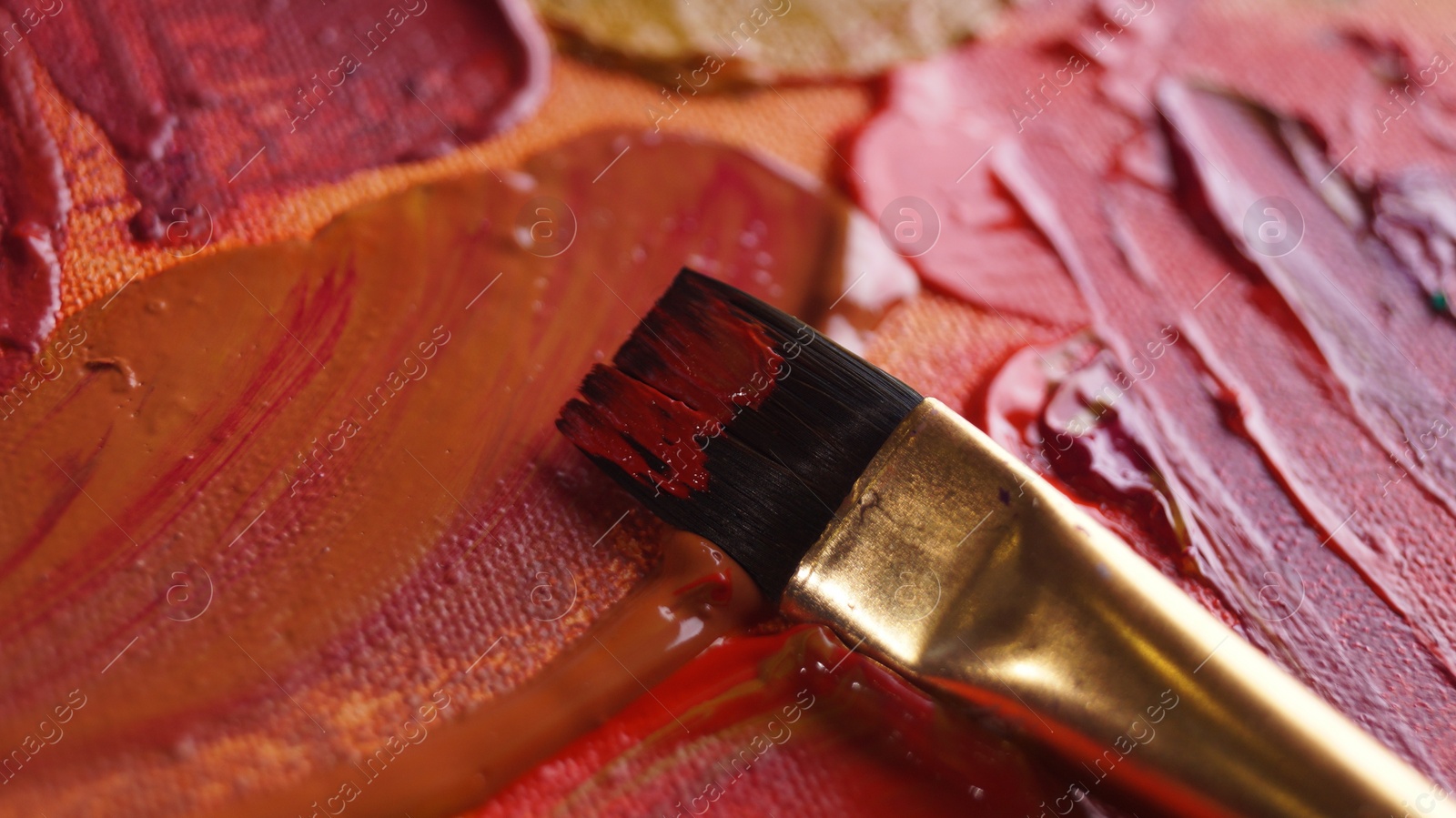 Photo of Brush on artist's palette with mixed paints, closeup