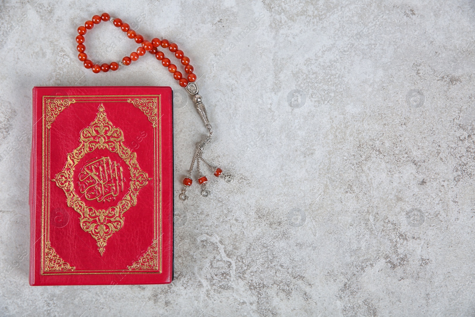 Photo of Muslim prayer beads, Quran and space for text on grey background, top view