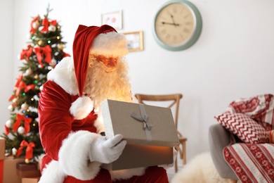 Authentic Santa Claus with gift box indoors