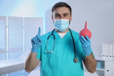 Photo of Doctor holding rubber enema in examination room