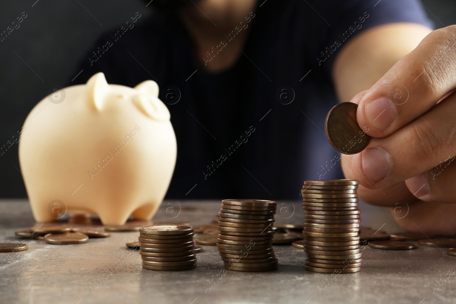 Photo of Man stacking coins on brown marble table, closeup