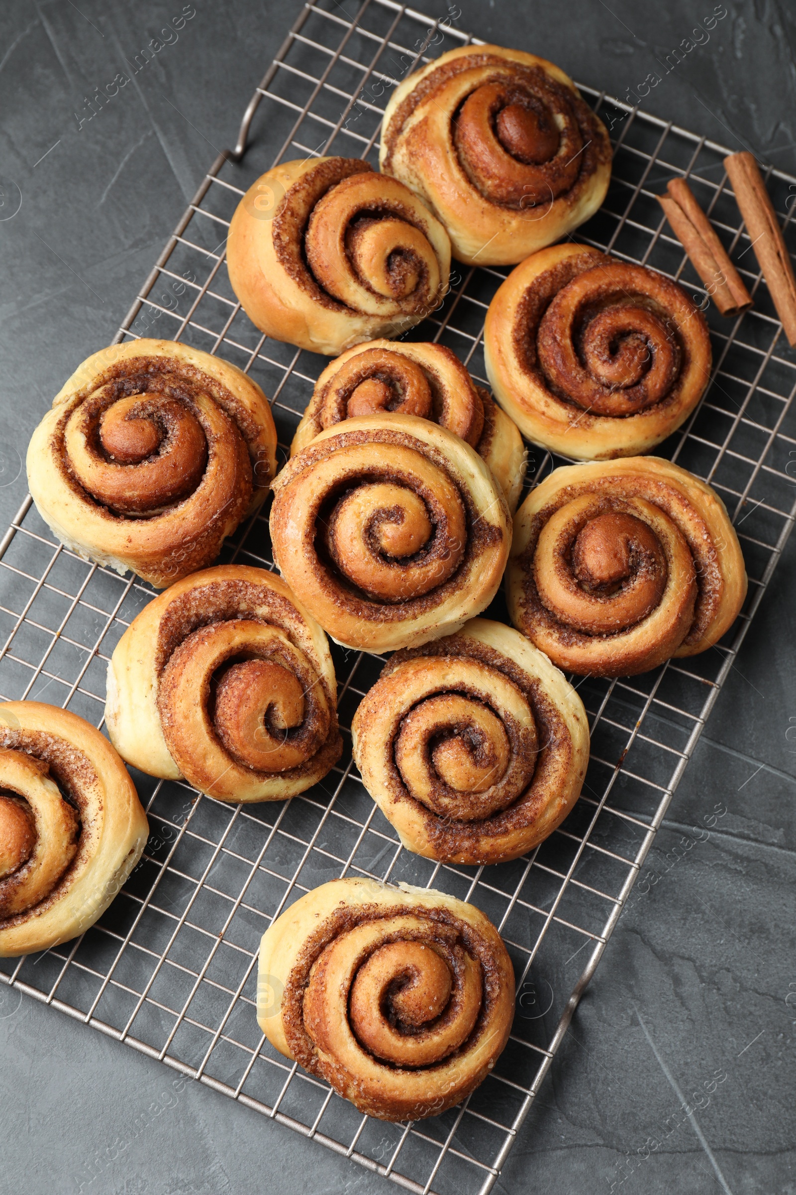 Photo of Tasty cinnamon rolls on black table, top view