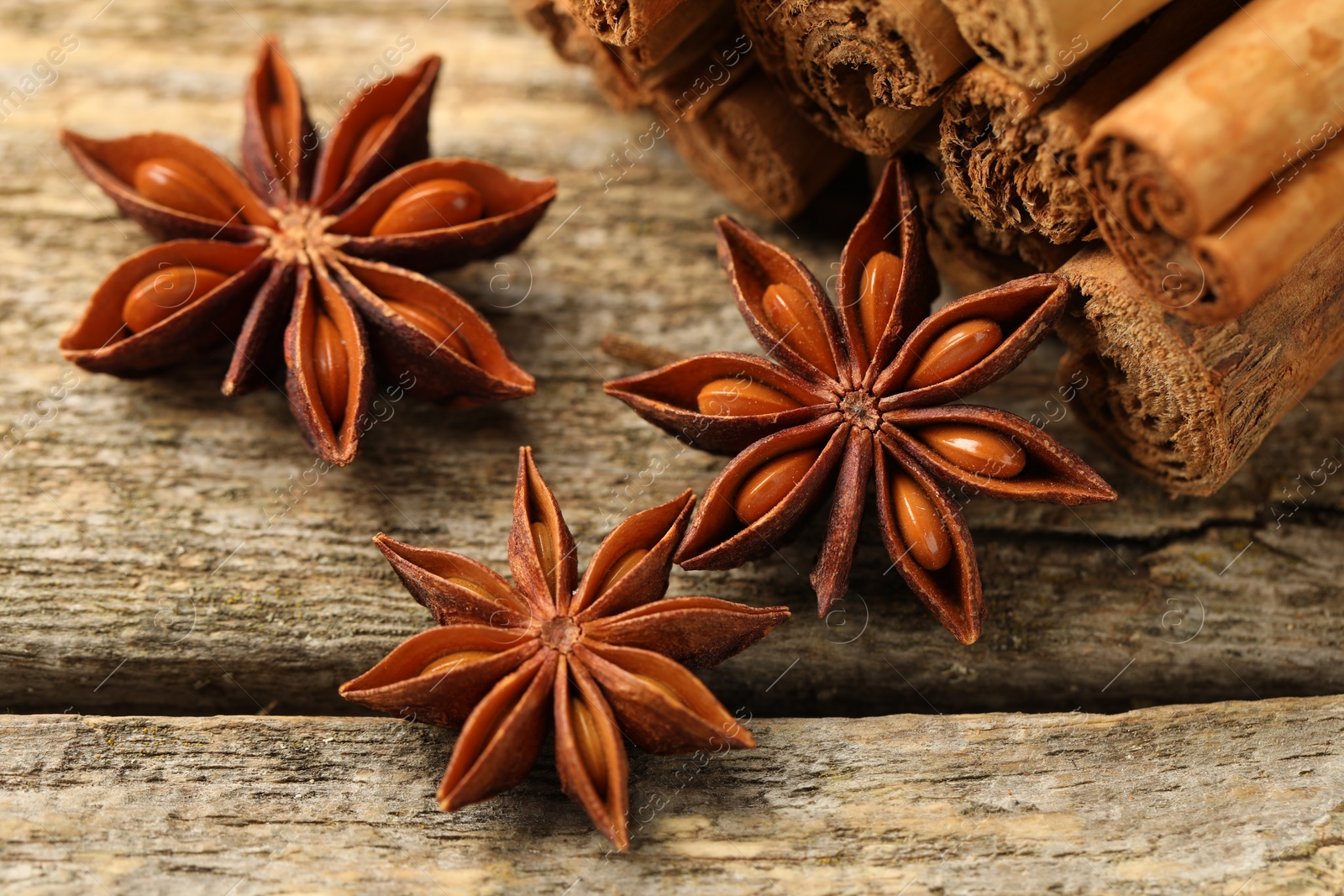 Photo of Cinnamon sticks and star anise on wooden table, closeup