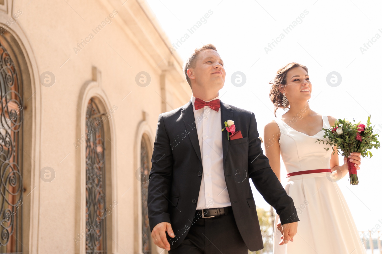 Photo of Happy newlyweds with beautiful bridal bouquet outdoors