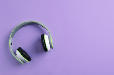 Photo of Wireless headphones on color background, top view. Space for text