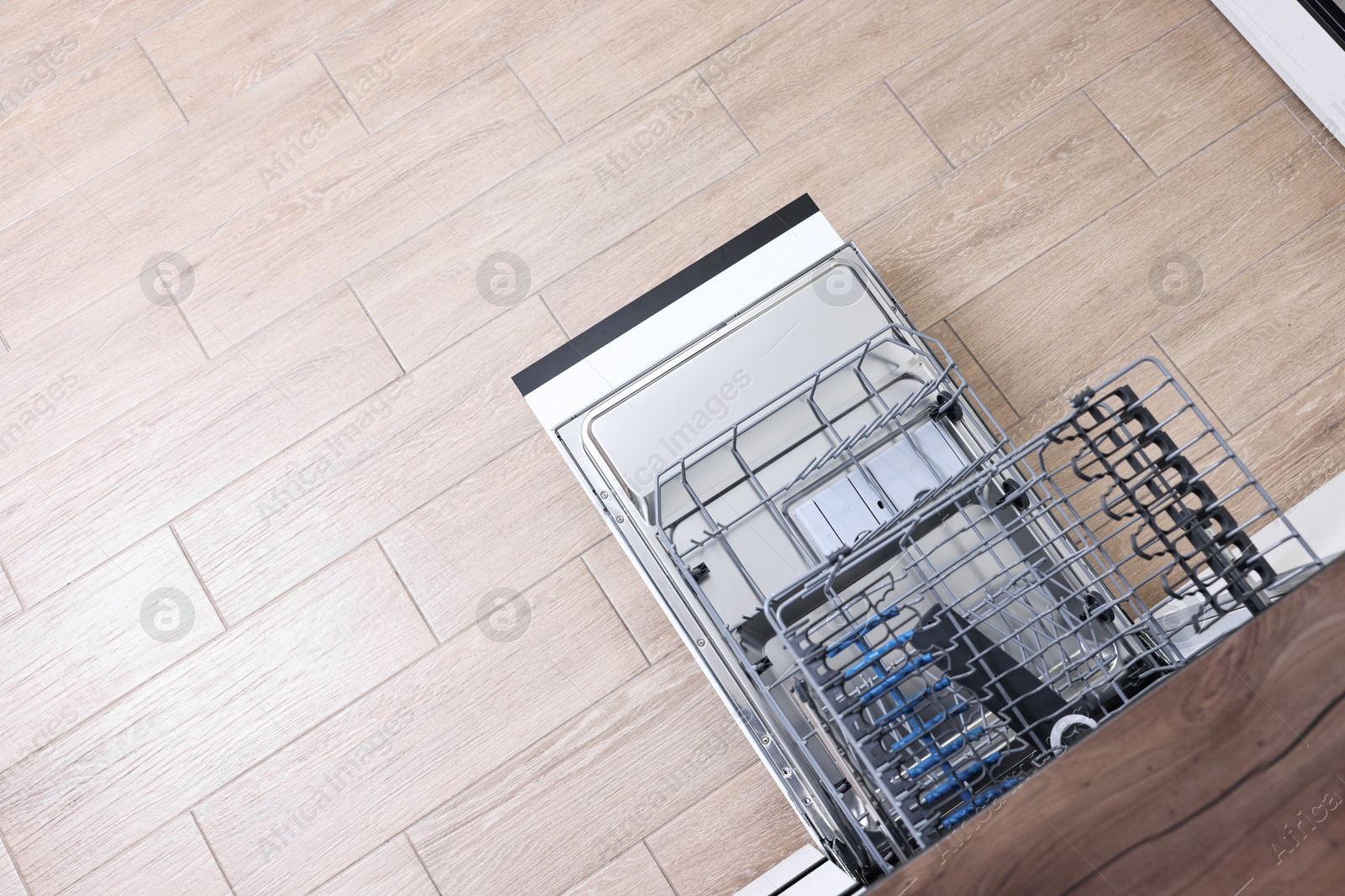 Photo of Open clean empty dishwasher in kitchen, top view. Space for text