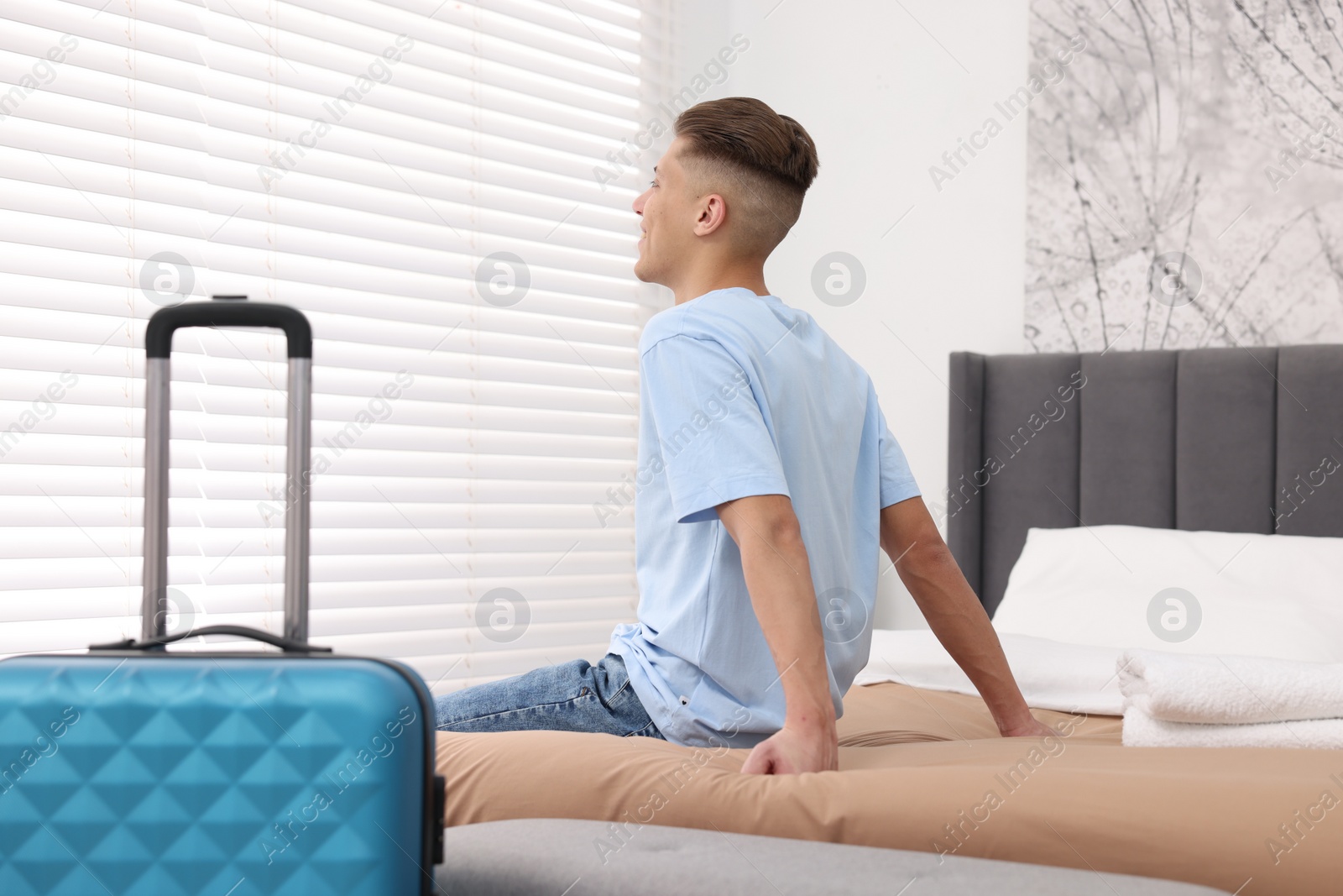 Photo of Guest relaxing on bed in stylish hotel room