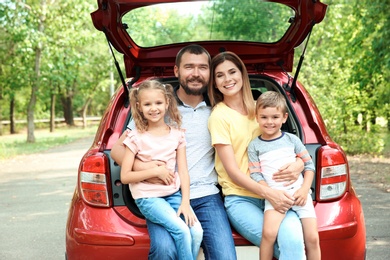 Photo of Happy family with children and car, outdoors. Taking road trip together