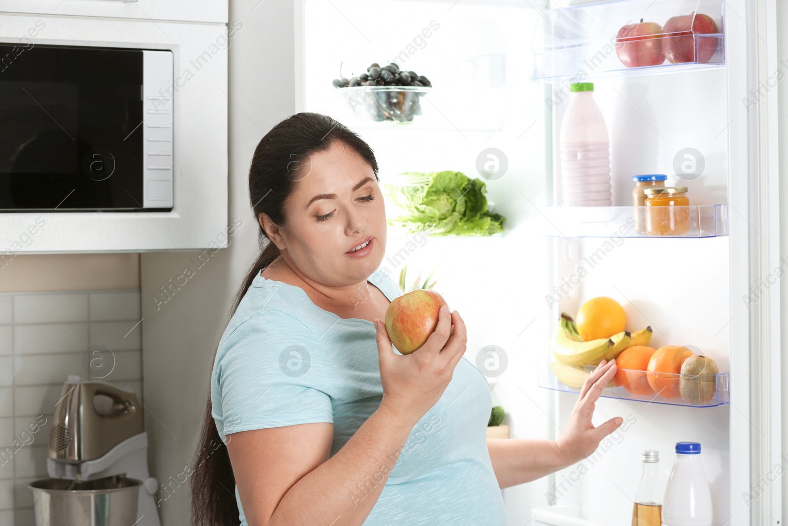 Photo of Woman choosing food from fridge at kitchen. Healthy diet