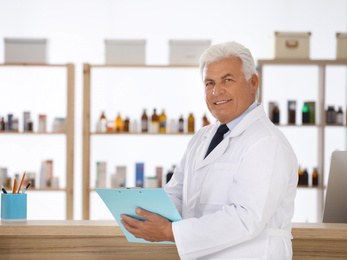 Photo of Professional pharmacist with clipboard in drugstore. Space for text