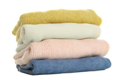 Stack of different warm sweaters isolated on white