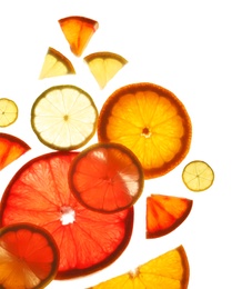 Illuminated slices of citrus fruits on white background, top view