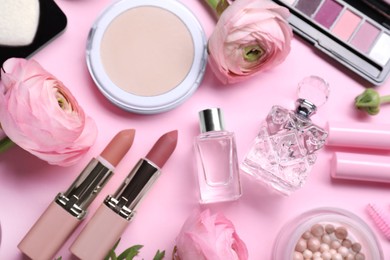 Photo of Flat lay composition with different makeup products and beautiful spring flowers on pink background