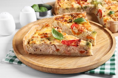 Photo of Tasty quiche with tomatoes, basil and cheese on white wooden table, closeup
