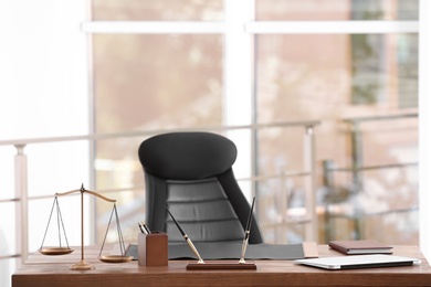 Table with scales of justice in lawyer's office