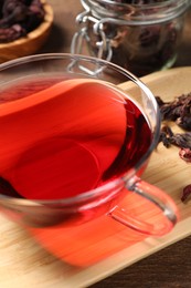 Photo of Cup of fresh hibiscus tea on table, closeup