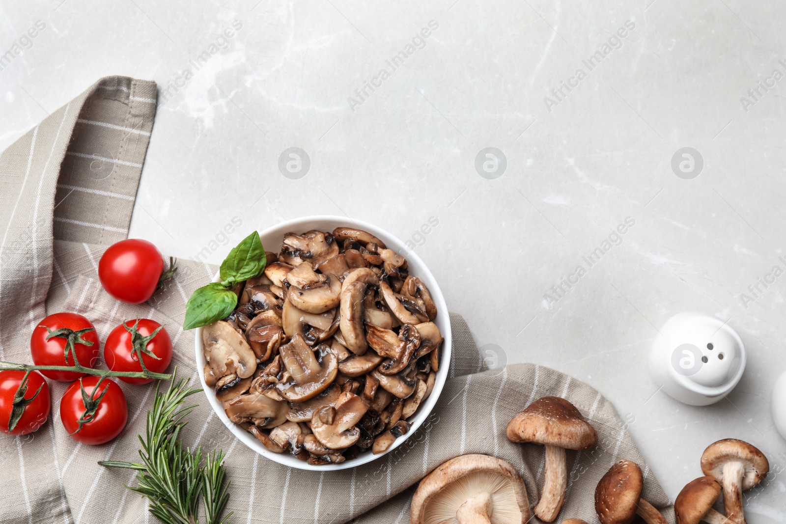 Photo of Flat lay composition with delicious cooked mushrooms on white marble table. Space for text