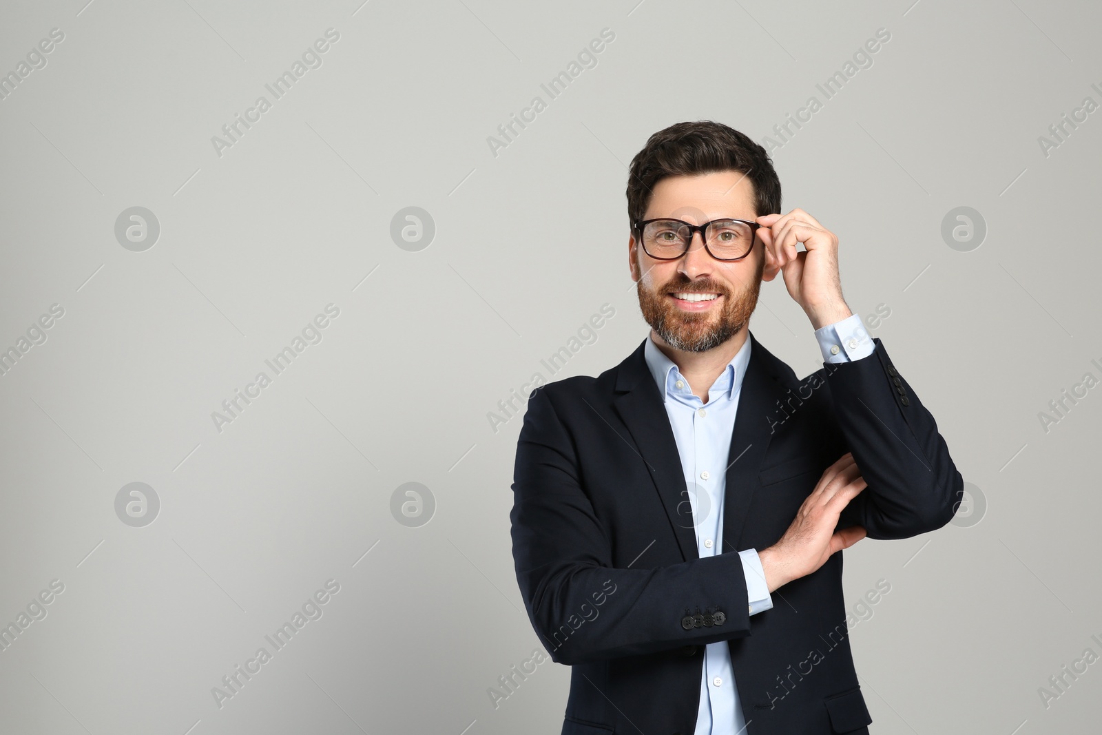 Photo of Handsome real estate agent in nice suit on grey background, space for text