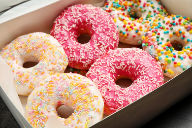 Sweet delicious glazed donuts on table, closeup